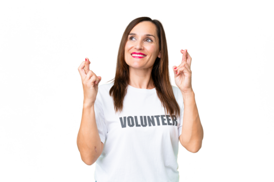 Middle age volunteer woman over isolated chroma key background with fingers crossing