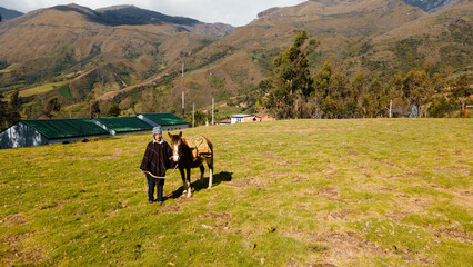 Hombre nativo quechua usando un chullo  junto a un caballo de montañés . Perú. Foto