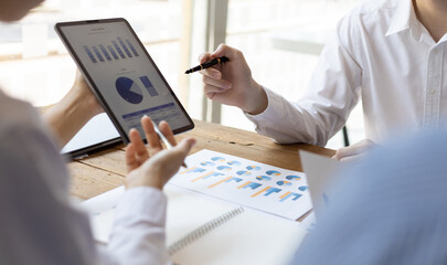 Business meeting, brainstorming sessions discuss analysis of investment growth graph and market charts in financial reports and business investment strategy planning.