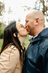 Naklejka premium Attractive affectionate young couple standing together and kissing in the street