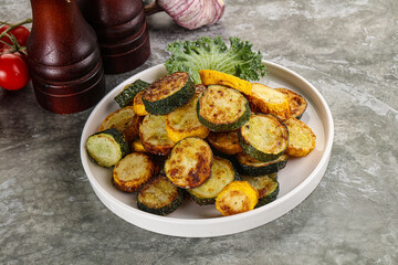 Roasted young zucchini in the plate
