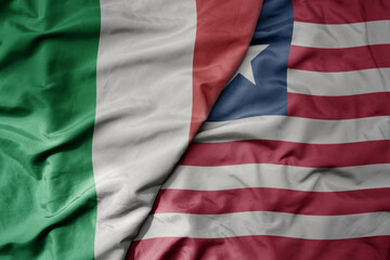 big waving national colorful flag of italy and national flag of liberia .