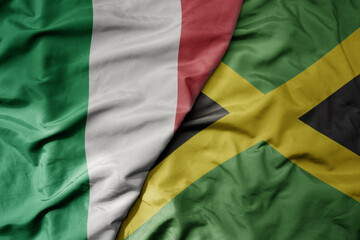 big waving national colorful flag of italy and national flag of jamaica .