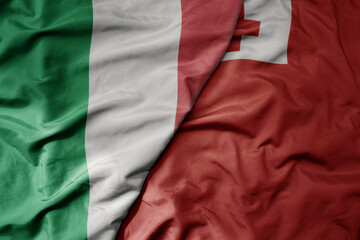 big waving national colorful flag of italy and national flag of Tonga .