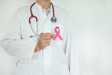 Doctor woman with pink ribbon on her chest, supporting symbol of breast cancer awareness