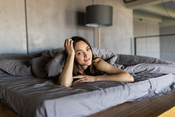 Fototapeta premium Lovely young woman posing in a bedroom