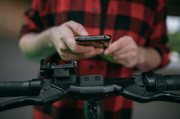 A young man rents a scooter through a mobile application.