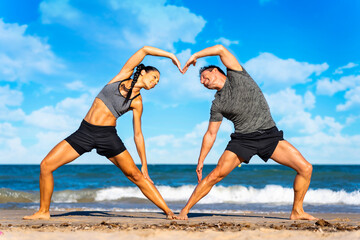Smiling couple doing yoga exercises outdoors