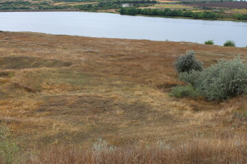 A landscape with a body of water and a field