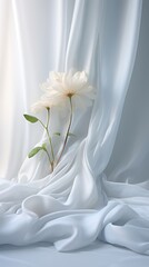 a flower on a spotless white draped in a soft white cloth. Still life photography and minimalist composition