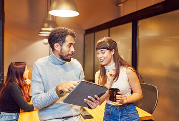 portrait two young people employees students in meeting room interior interacting with a digital tablet