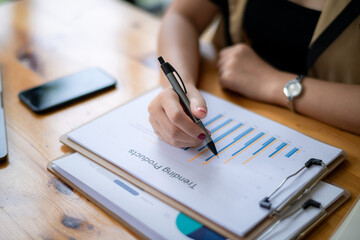 Cropped image of businesswoman analyzing business results by exploring trends of popular products in the market