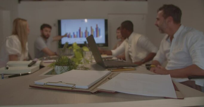 Diverse group of people working together on a project while discussing it and sharing ideas, male is presenting ideas to the team