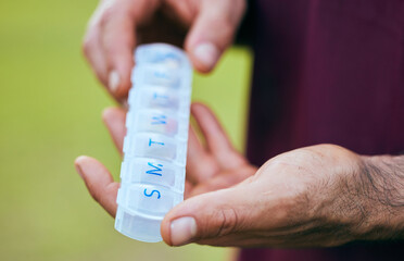 Pill box, weekly medicine and hand closeup of a sport athlete on a soccer field with tablet and drugs for health. Supplements, plastic container and outdoor with a man holding wellness and medication