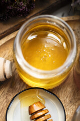 fresh natural  linden honey  glass jar with wooden  honey spoons around herb flowers. close up