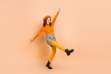 Fototapeta na wymiar Full length photo of carefree crazy funky lady wear trendy orange clothes have fun good mood isolated on beige color background