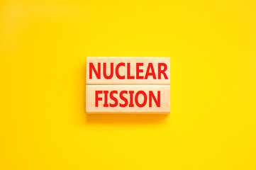 Nuclear fission symbol. Concept words Nuclear fission on beautiful wooden blocks. Beautiful yellow table yellow background. Business science nuclear fission concept. Copy space.