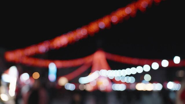 New Year's Eve at an outdoor market, background and image out of focus, red garlands. People
