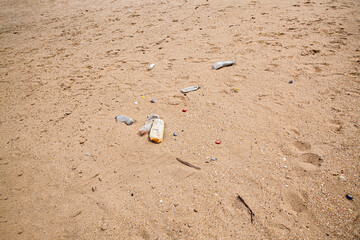 orilla del mar con contaminación de plásticos y residuos  sobre la arena de la playa