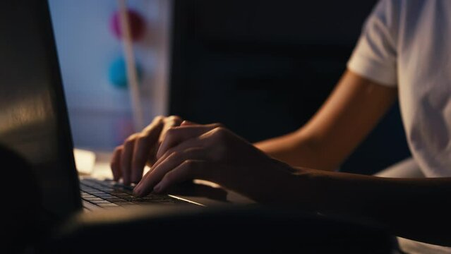 Close up of teenage girl studying at home with laptop in bedroom desk at night - shot in slow motion