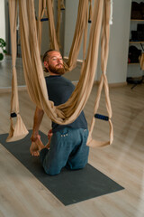 male yogi stretches his back lying on the floor to improve body flexibility and physical health
