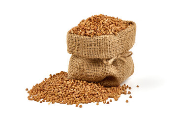 Raw buckwheat grains in rustic burlap isolated on white background.