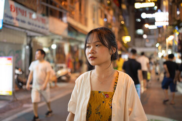 Portrait of happy Asian Vietnamese woman travel at night market people walking street fair in Hanoi city, Vietnam. Retail shops