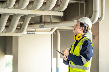 Building inspector man using digital tablet checking plumbing pipeline system. Asian male worker in...