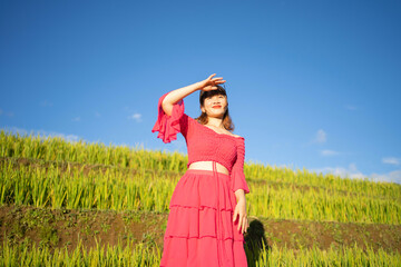 A farmer woman with fresh paddy rice terraces, green agricultural fields in countryside or rural area of Mu Cang Chai, mountain hills valley in Asia, Vietnam. Nature landscape. People lifestyle.