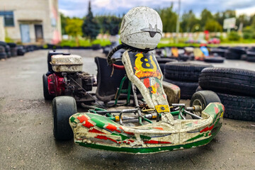 Kart, Small racing car after the race, dirt on the frame and wheels, Steering wheel protective helmet.