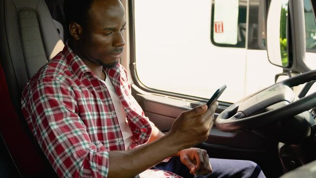 Black trucker preparing for trip. Professional trucker using truck gps navigation to transport and deliver goods to the destination