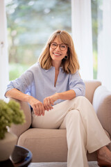 Portrait of an attractive mid aged woman relaxing in an armchair at home