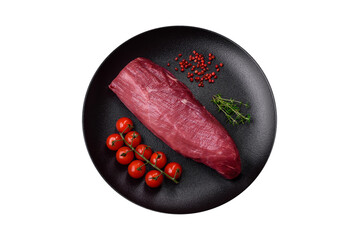 Juicy raw beef with spices, salt and herbs on a dark concrete background