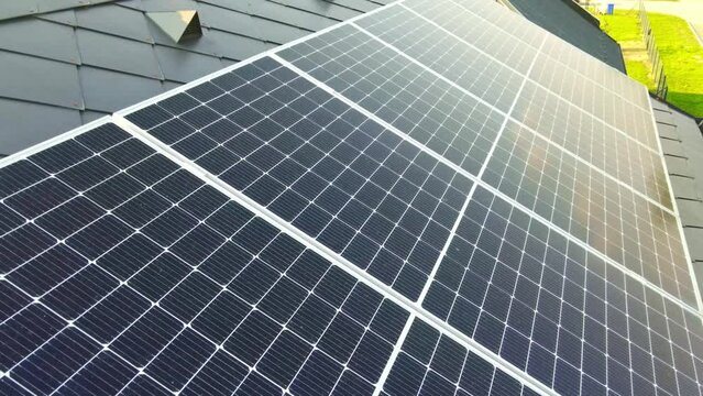 Aerial view to new modern solar panels on the roof of a luxury house, alternative energy source for home, green energy from the sun, industrial concept