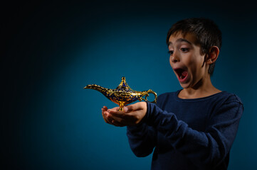 Amazed child with magic Aladin lamp in hand