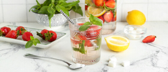 Glass of fresh strawberry lemonade on light table