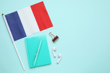 Flag of France with stationery and earphones on blue background