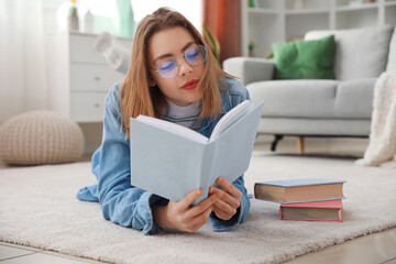 Young woman reading book on floor at home