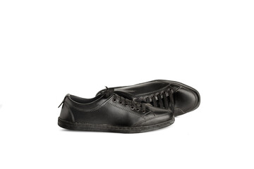 Unas zapatillas negras sobre un fondo blanco liso y aislado. Vista de frente y de cerca. Copy space