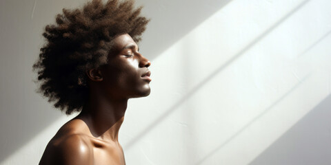 Fototapeta na wymiar young man's textured afro, capturing its volume and natural beauty against a stark white background, room for copyspace