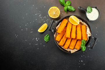 Fish fingers sticks on a dark background. banner, menu, recipe place for text, top view