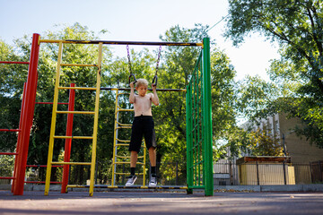 Street workout on a horizontal bar in the school park.