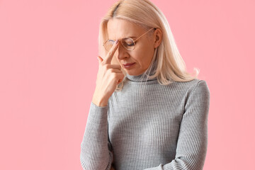 Thoughtful mature woman on pink background