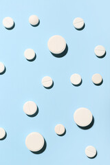 White pills on blue background