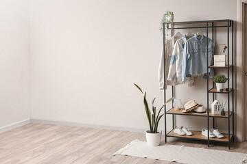 Shelving unit with clothes and accessories in modern hall