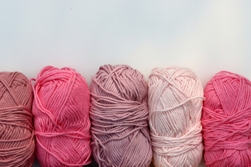 Pink and purple clews of yarn close up photo. Beautiful soft organic cotton on a table. 