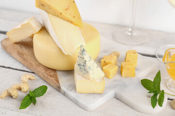 Board with different types of tasty cheese on table