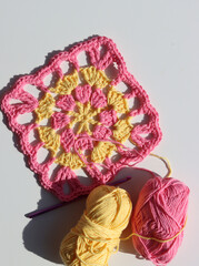Yellow and pink crochet pattern. Easter crochet ideas. Fluffy and soft cotton yarn close up photo. White background with space for text. 