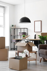 Interior of light office with cardboard boxes on moving day