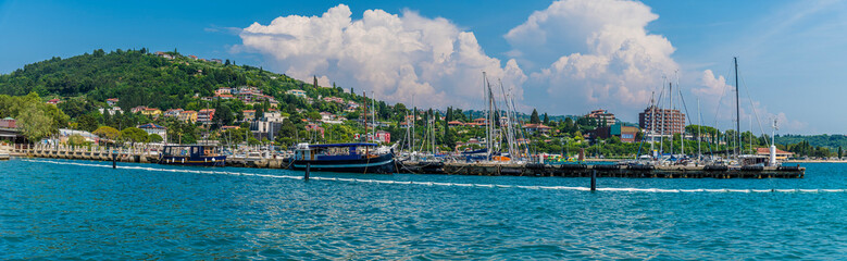 A panorama view past boats moored on the harbour wall at Portoroz, Slovenia in summertime